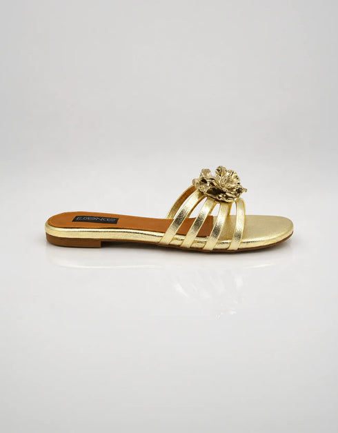 Side view of Imperial gold strappy flat sandals showing comfort sole and metallic flower detail