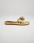 Side view of Imperial gold strappy flat sandals showing comfort sole and metallic flower detail