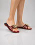 Model wearing Imperial maroon flower embellished flat sandals for formal occasion