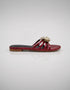 Side view of Imperial maroon patent flat sandals showing comfort sole and metallic flower detail