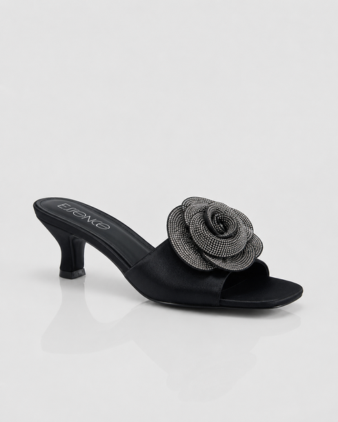 Black sandal with a decorative flower on a white background