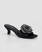 Black sandal with a decorative flower on a white background